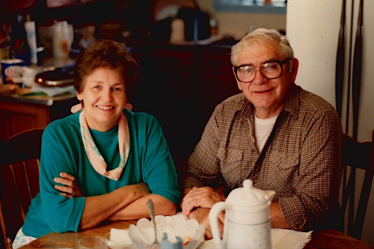 Lois and Budd sitting at the kitchen table.